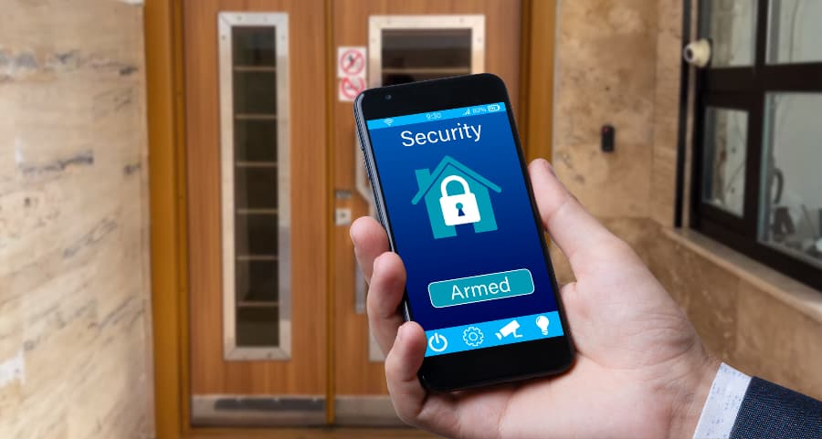 Person using smartphone to arm a home security system